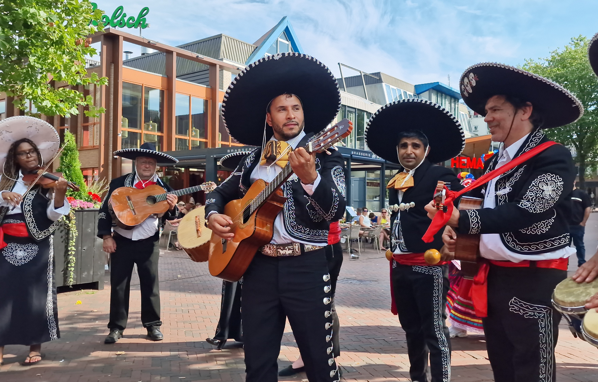 Mariachi-ensemble met gitaren, viool en sombrero’s buiten